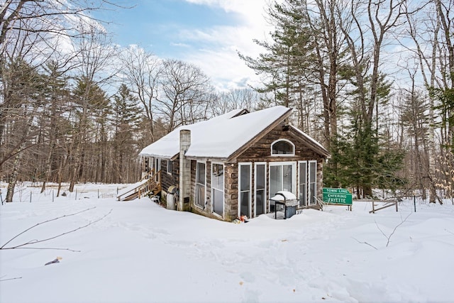 snow covered structure with a sunroom