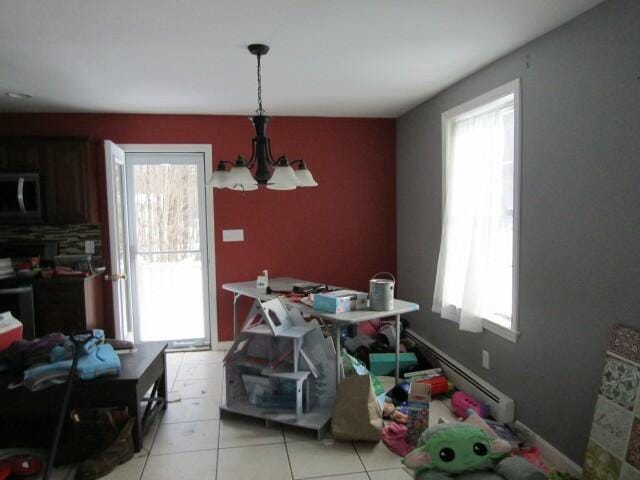 dining area with a notable chandelier, plenty of natural light, and light tile patterned floors