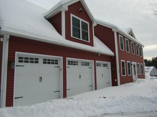 snow covered property featuring a garage