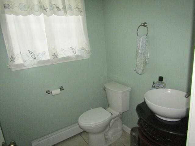 bathroom featuring baseboards, toilet, tile patterned flooring, vanity, and a baseboard heating unit