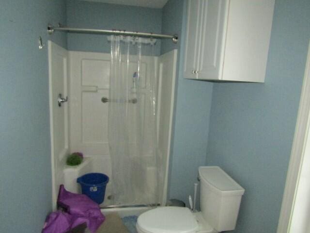 full bath featuring toilet and a stall shower