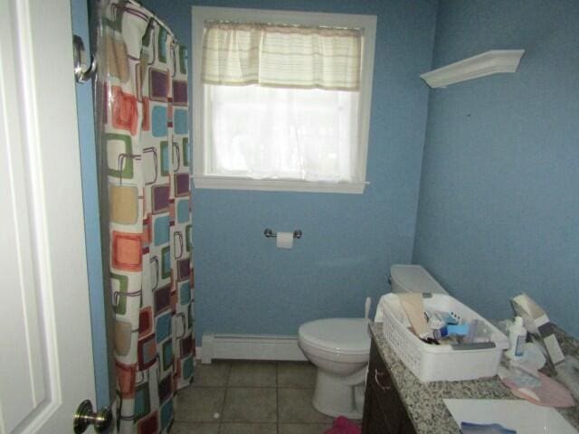 full bathroom with baseboards, toilet, tile patterned floors, baseboard heating, and vanity