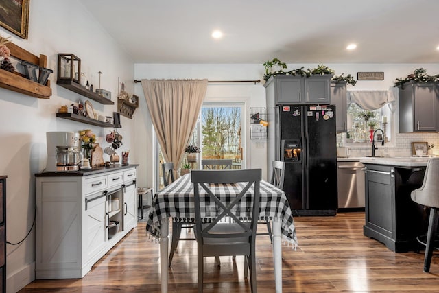 dining space featuring recessed lighting, a healthy amount of sunlight, and dark wood finished floors