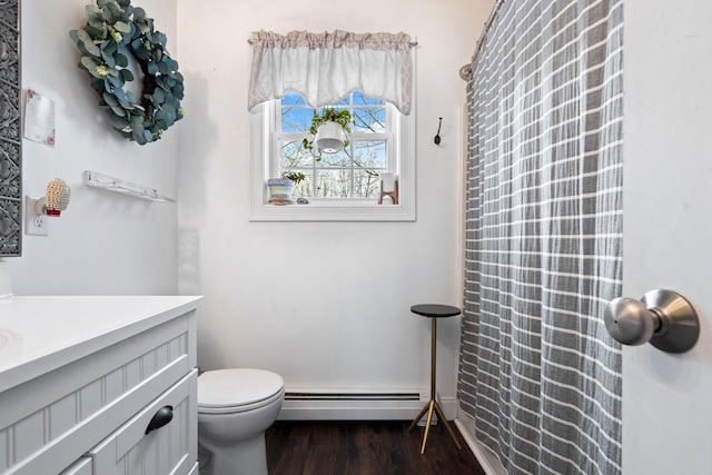 full bathroom with toilet, a baseboard radiator, wood finished floors, and vanity