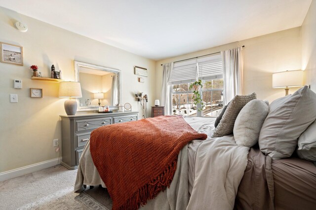 bedroom with baseboards and light colored carpet