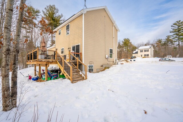 snow covered property featuring a deck and stairs