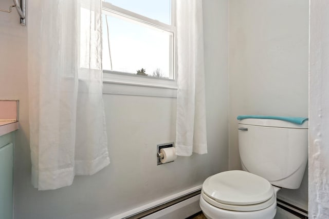 bathroom with baseboard heating, a baseboard radiator, and toilet