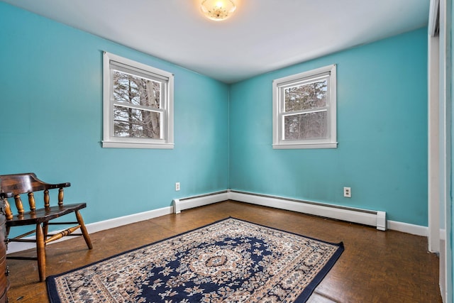 living area with baseboards and a baseboard heating unit