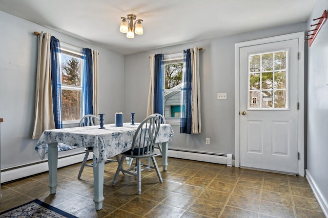 dining space featuring a notable chandelier, baseboard heating, and baseboards