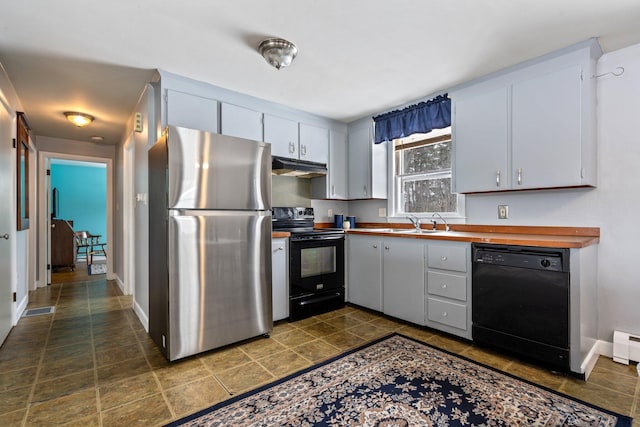 kitchen featuring under cabinet range hood, a sink, visible vents, white cabinetry, and black appliances