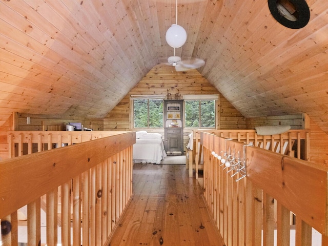 additional living space with wood ceiling, vaulted ceiling, wood walls, and hardwood / wood-style flooring