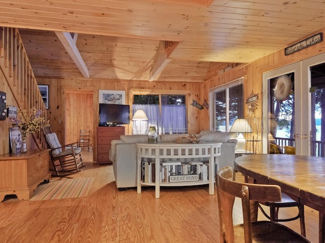 living room with vaulted ceiling, wood walls, wooden ceiling, and wood finished floors