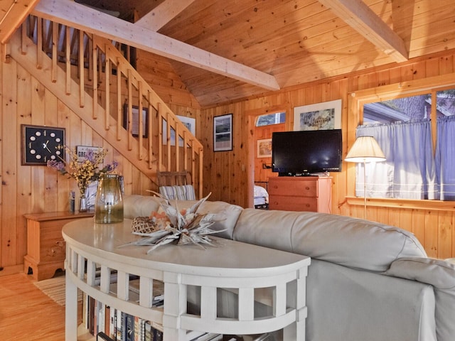 living area with wood ceiling, wood walls, stairway, and lofted ceiling with beams