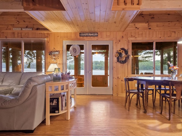 interior space with wood ceiling, a healthy amount of sunlight, wood walls, and french doors