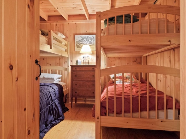 bedroom with wood walls and wood finished floors