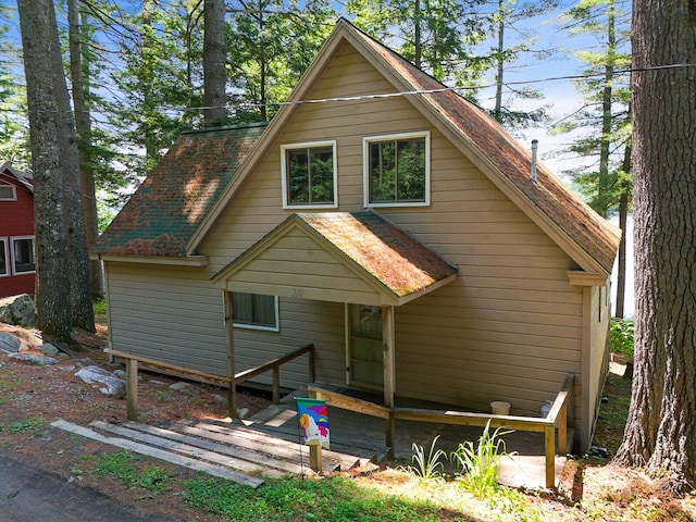 back of house with roof with shingles