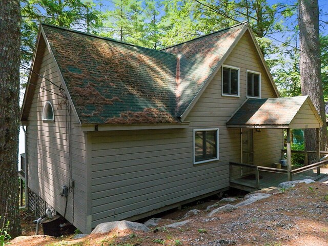 back of house with a shingled roof