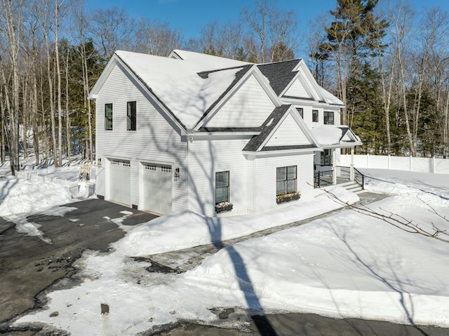 view of front of home with roof with shingles, driveway, and an attached garage