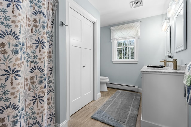 full bath featuring a baseboard radiator, visible vents, toilet, vanity, and wood finished floors