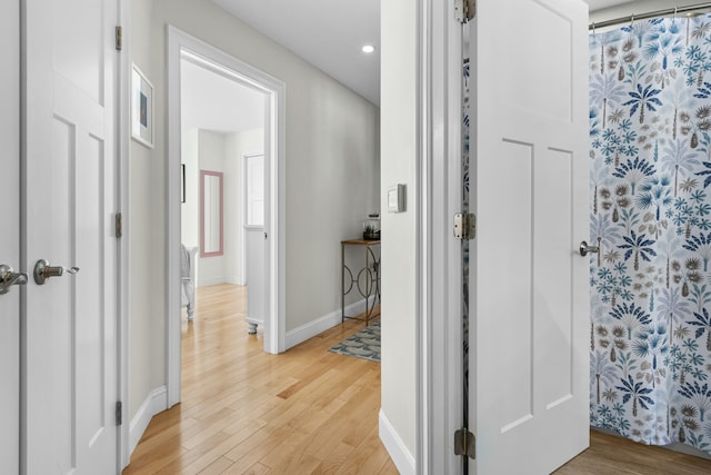 corridor featuring light wood-style floors, recessed lighting, and baseboards