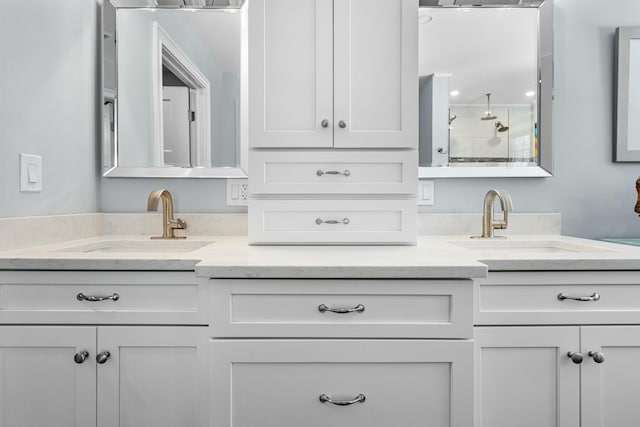 bathroom featuring a sink, a tile shower, and double vanity