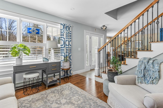 interior space featuring stairs, a baseboard radiator, hardwood / wood-style flooring, and baseboards