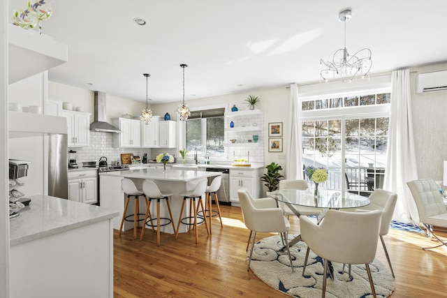 dining area with a wall unit AC, recessed lighting, light wood finished floors, and a chandelier