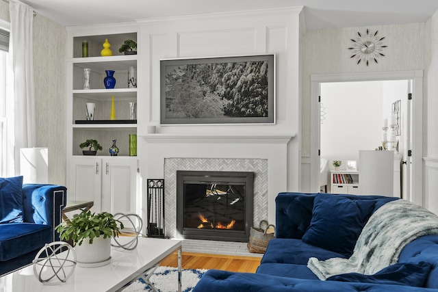 living room featuring wood finished floors, built in features, and a fireplace