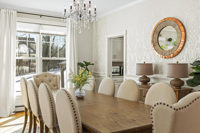 dining area featuring light wood-type flooring, a notable chandelier, wallpapered walls, wainscoting, and crown molding