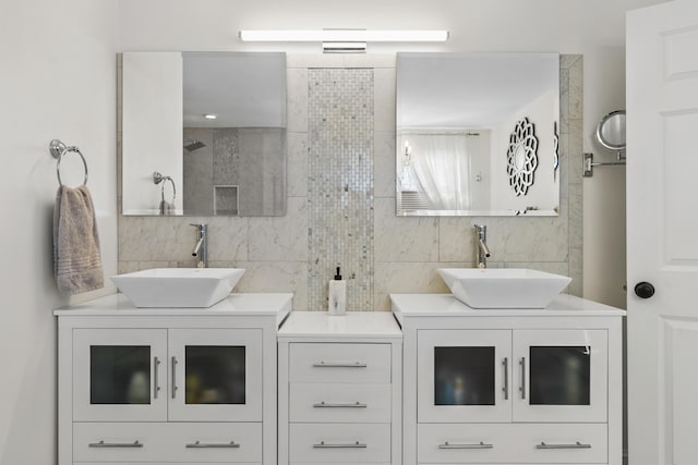 bathroom featuring tasteful backsplash, two vanities, and a sink