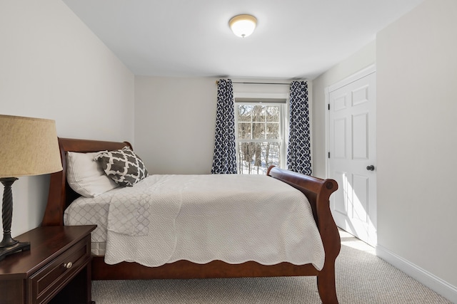 bedroom featuring baseboards and carpet