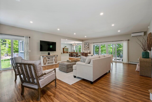 271 Red Gate Ln, Acton, ME 04001 - living room with a wall mounted air conditioner, baseboard heating, wood finished floors, recessed lighting, and a chandelier