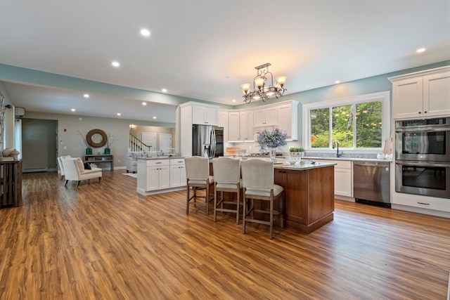 271 Red Gate Ln, Acton, ME 04001 - kitchen with appliances with stainless steel finishes, a center island, wood finished floors, white cabinetry, and recessed lighting