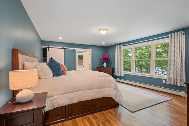 271 Red Gate Ln, Acton, ME 04001 - bedroom with baseboard heating, wood finished floors, a barn door, and recessed lighting
