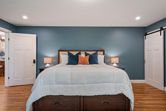 271 Red Gate Ln, Acton, ME 04001 - bedroom with a barn door, wood finished floors, and recessed lighting