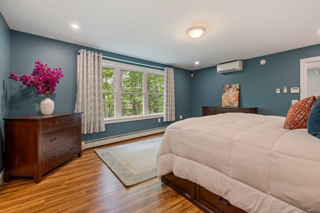 271 Red Gate Ln, Acton, ME 04001 - bedroom featuring a baseboard heating unit, an AC wall unit, light wood-style flooring, and recessed lighting