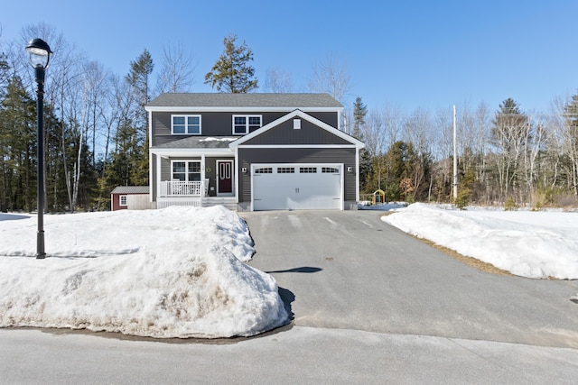 view of front of home featuring covered porch, aphalt driveway, and a garage