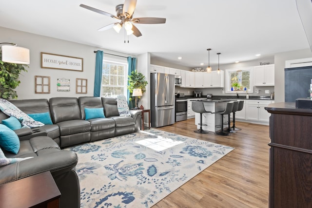 living area with ceiling fan, recessed lighting, and light wood-style floors