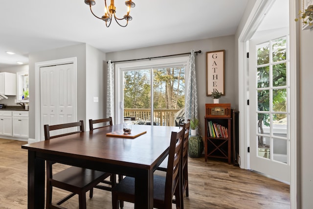 dining space featuring light wood-style floors and a notable chandelier