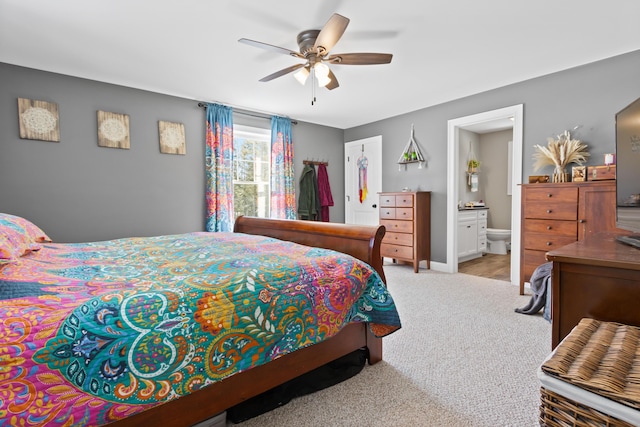 bedroom featuring a ceiling fan, ensuite bath, a walk in closet, carpet floors, and a closet