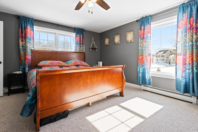 bedroom featuring a baseboard heating unit, carpet flooring, baseboards, and a ceiling fan