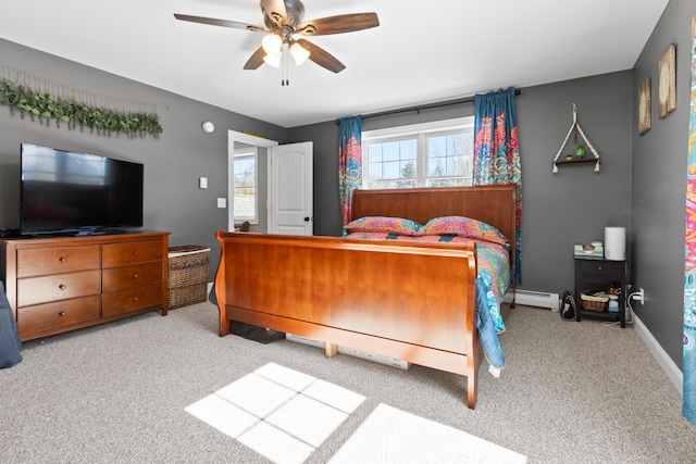 carpeted bedroom featuring baseboard heating, a ceiling fan, and baseboards