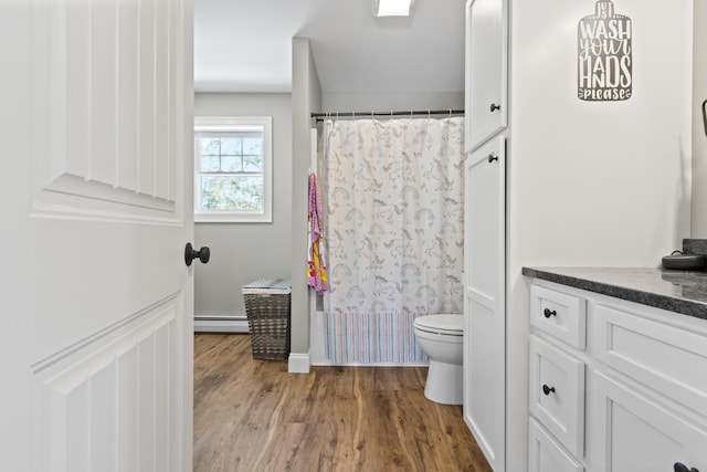 bathroom featuring baseboard heating, wood finished floors, toilet, and a shower with curtain