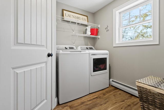 washroom featuring laundry area, a baseboard radiator, wood finished floors, and washer and dryer