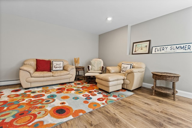 living room featuring a baseboard heating unit, baseboards, wood finished floors, and recessed lighting