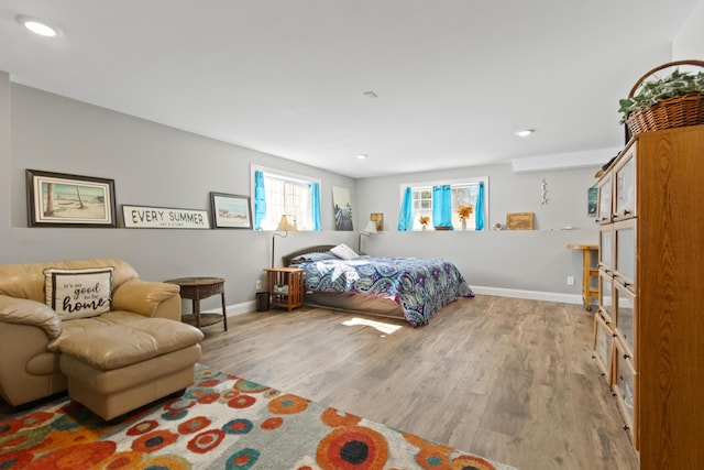 bedroom with recessed lighting, wood finished floors, and baseboards