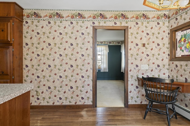 dining room with baseboards, wallpapered walls, and wood finished floors