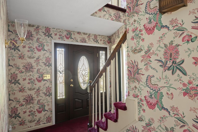 foyer entrance with stairway and wallpapered walls