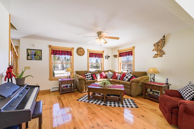 living room featuring ceiling fan, light wood-type flooring, a baseboard radiator, and a wealth of natural light