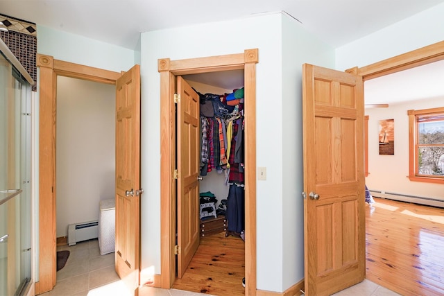 hall with light wood finished floors and a baseboard radiator